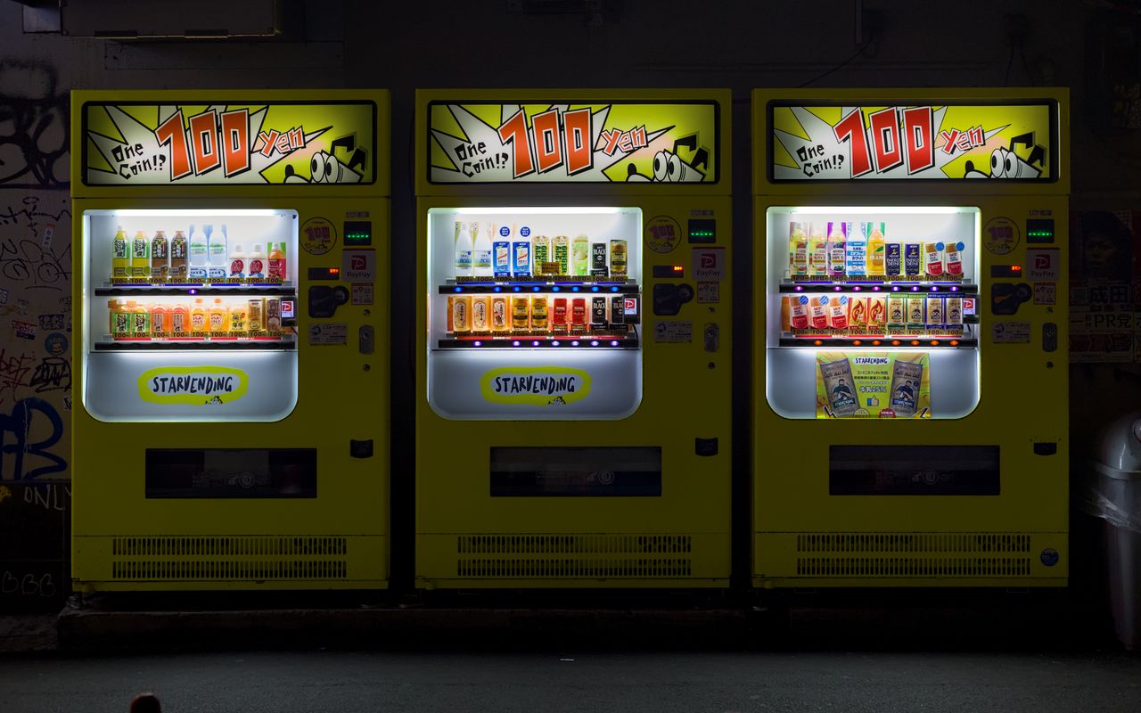 Crafting Captivating Headlines: Your awesome post title goes here Three brightly lit vending machines on an urban street in Osaka, Japan at night.